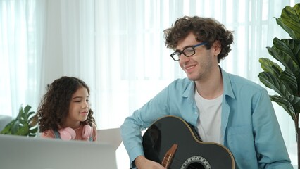 Skilled caucasian father playing guitar to relax daughter after learning engineering prompt and...