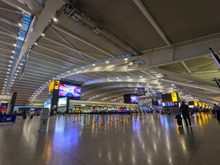 Travelers and staff navigate the modern, spacious Heathrow Airport Terminal 5 departure area in...