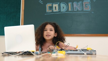 Attractive african student programing system while looking at screen. American girl working on her...