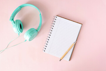 Notebook on the table. Blank notebook with space for a message. Pens, headphones