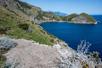 Fototapeta na wymiar Ieranto Bay seen from afar from the promontory of Punta Campanella, on a sunny day with blue sea. Massa Lubrense.
