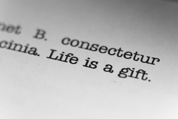 Obraz premium Life is a gift. Text printed on a page. A piece of paper with a phrase written in retro typewriter font.