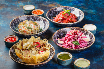 Bowls filled with different types of food including Middle Eastern salads. Table with many bowls with food on it.