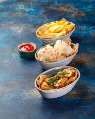 Various types of snacks, French fries, chips, cauliflower in spices and tomato sauce