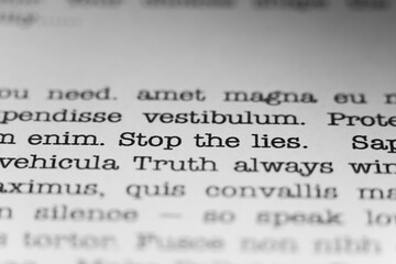 Fototapeta premium Stop the lies. Truth always wins. Text printed on a page. A piece of paper with a phrase written in retro typewriter font.