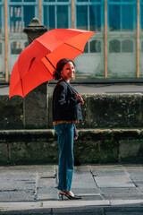young woman with umbrella on monumental street