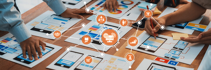 A group of professionals collaborates in a modern workspace, interacting with various digital interfaces and visual data, showcasing teamwork and creativity in planning. Amity