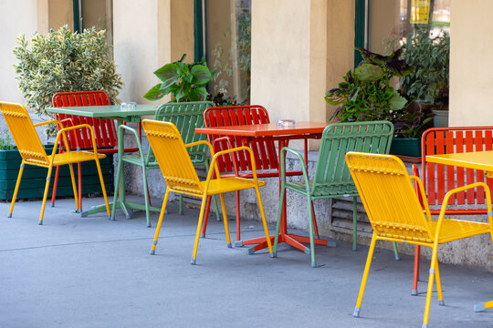 An outdoor outdoor cafe with tables and chairs with no customers.