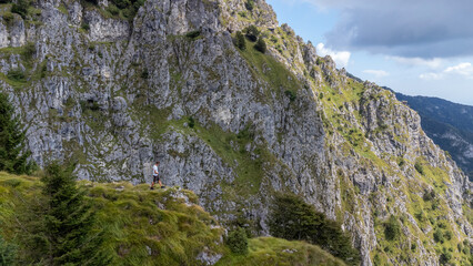 Man alone seen from behind admiring nature. Boy hiking in the mountains admiring the beauty of nature and the landscape in front of him, lifestyle and freedom