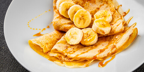 Crepes banana syrup pancakes breakfast dish dessert organic product fresh tasty gourmet food background on the table rustic food top view copy space