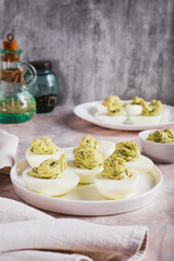 Eggs stuffed with avocado and yolk mixture on a plate on a table vertical view