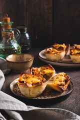 Mini tartlets with caramelized onions and cheese on a plate on a table vertical view