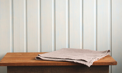 Empty wooden table with beige waffle towel on white background
