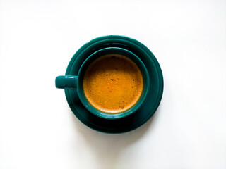 Green ceramic cup filled with coffee, placed on white background
