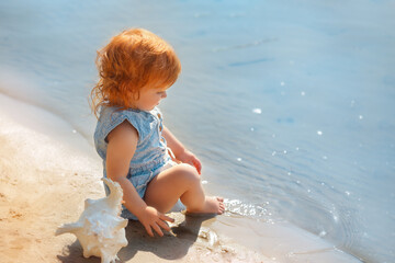 Curious Red-haired Toddler Playing by the Sea Description: