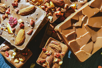 Handmade chocolate close-up. Assorted chocolate with almonds, freeze-dried raspberries and strawberries. . Background for using banners and menus. High quality photo