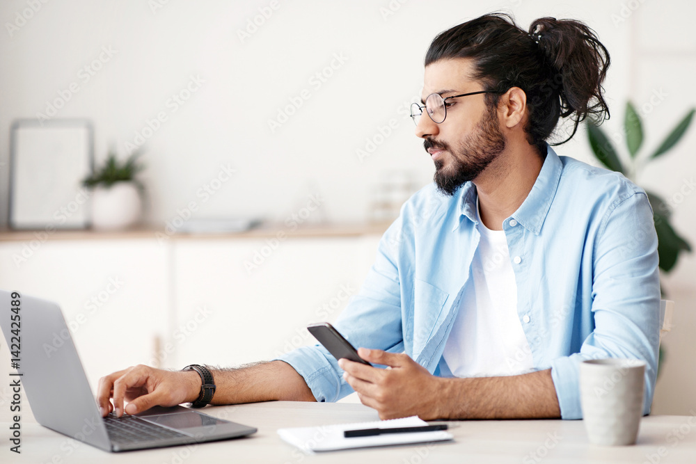 Poster millennial western freelancer guy working remotely from home office with smartphone and laptop, sitt