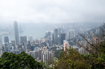 Fototapeta premium Hong Kong. China- 03.01.2025. A mountain view of the Hong Kong island city sky line showing the many skyscrapers on a very misty day.