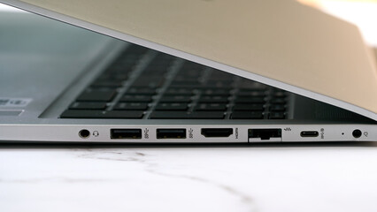 Close up detail of the side panel connectivity on a modern laptop, showing various input and output...