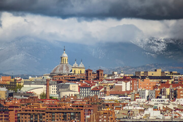Panoramic view of Madrid, the capital of Spain, with the partially snow-covered mountains in the background.