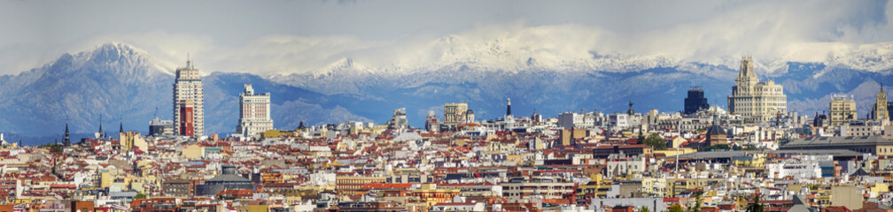 Panoramic view of Madrid, the capital of Spain, with the partially snow-covered mountains in the background.