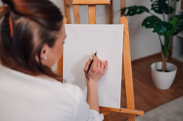 Female artist starting new painting on canvas in art studio