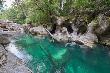 Lovely hidden place named Puente piedra or Stone bridge over the Picacho River, Patagonia, Chile. Turquoise crystal water of the river. Huge rock formation under water. Tourist attraction.