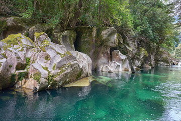 Lovely hidden place named Puente piedra or Stone bridge over the Picacho River, Patagonia, Chile. Turquoise crystal water of the river. Huge rock formation under water. Tourist attraction.