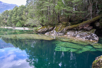 Lovely hidden place named Puente piedra or Stone bridge over the Picacho River, Patagonia, Chile. Turquoise crystal water of the river. Huge rock formation under water. Tourist attraction.