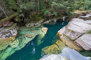 Lovely hidden place named Puente piedra or Stone bridge over the Picacho River, Patagonia, Chile. Turquoise crystal water of the river. Huge rock formation under water. Tourist attraction.