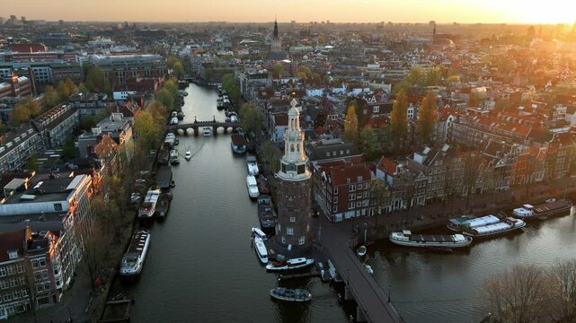 Amsterdam aerial view at sunset with canals, boats and a bell tower, historic Dutch city of Amsterdam, capital of the Netherlands