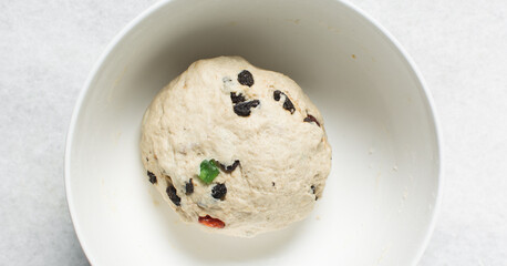 Overhead view of hot cross bun dough on a white granite countertop, top view of hot cross bun dough on a white background, process of making hot cross buns
