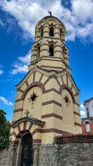 Historic Orthodox Church Bell Tower Built In 1905 With Cream And Red Brick Façade, Cross On Top,...
