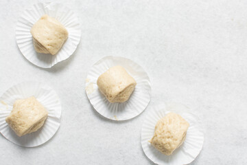 Overhead view of steamed bun dough on a white countertop, top view of mantou dough, process of making steamed milk buns