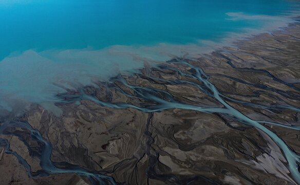 Aerial panorama view of braided river arms streams delta, glacial pristine clear azure blue Southern Alps mountain water at Lake Pukaki, New Zealand