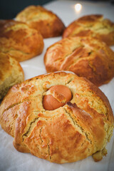 Close-up of freshly baked folar, a traditional Portuguese Easter bread with a whole egg in the center, symbolizing rebirth and celebration