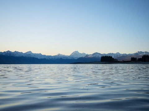 Low angle Mount Cook Aoraki mountain panorama at Lake Pukaki with water ripples waves, alpine soft light Southern Alps sunset landscape, New Zealand