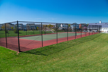 Fototapeta premium Tennis court on a residential development with rows of single family homes.