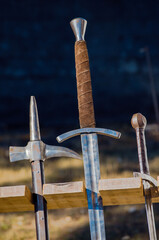 ancient arms displayed vertically in a wooden stand in a reenactment medieval event medieval combat weapons