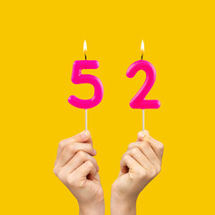 Birthday number 52 - Hands holding fuchsia colored candles