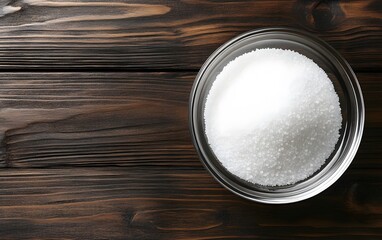 White Granulated Sugar in Glass Bowl on Wooden Background