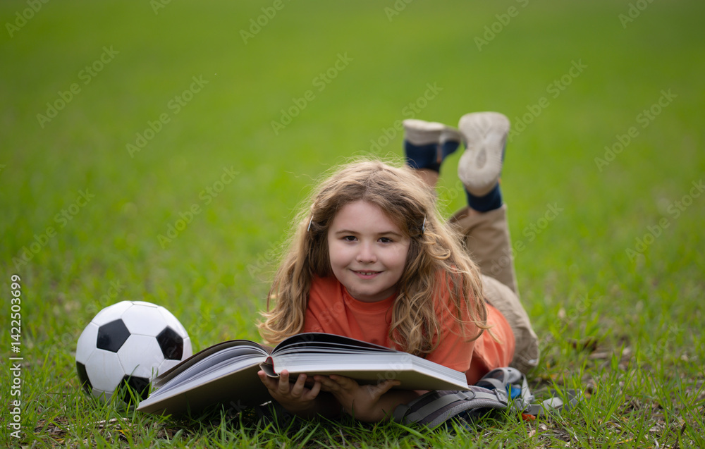 Poster child reading a book in the grass. kid enjoying a book story outdoors. child studying with book in t