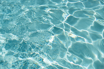Ripple Water in swimming pool with sun reflection. Wavy water background.