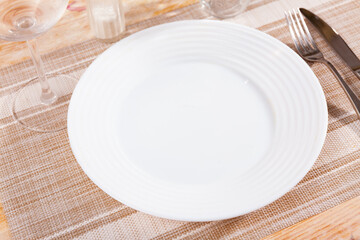 Table setting before the festive banquet - plate, knife and fork