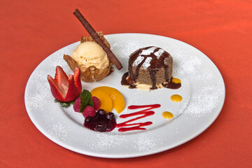 Delicious chocolate fondant with red berries and peach with vanilla ice cream, desserts