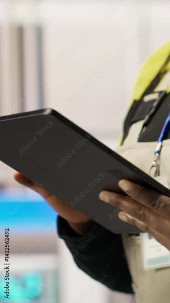 Poster vertical video engineer in smart factory oversees robotic assembly lines using tablet app, ensuring 