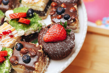 Delicious sweet desserts. Colorful cakes with fruits. Tasty chocolate muffin. Strawberry and blueberry topping. Homemade pastry. Elegant party sweets. Gourmet plate. Celebration treats. Natural fruit 