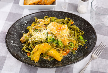 Pasta with chicken, broccoli cabbage, served with grated parmesan cheese, small pieces of rye bread. Traditional dish of Italian cuisine, treat in restaurant for connoisseurs of Mediterranean cuisine