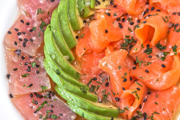 Tuna and salmon carpaccio with avocado and sesame seeds, salmon and tuna tiradito, food