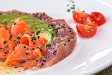 Tuna and salmon carpaccio with avocado and sesame seeds, salmon and tuna tiradito, food